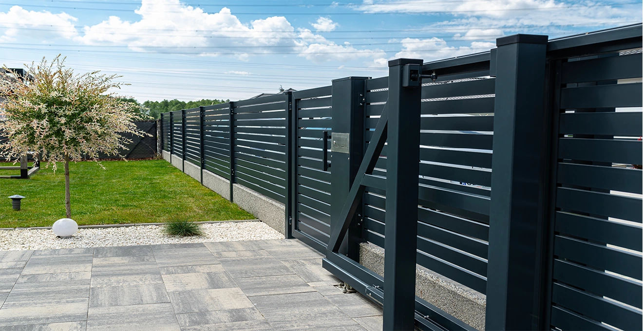 Different fence material samples including wood, metal, and composite panels displayed side by side.